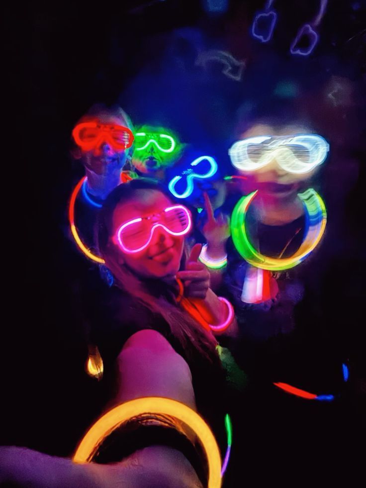 Invitados con lentes de neón y pulseras brillantes en la oscuridad