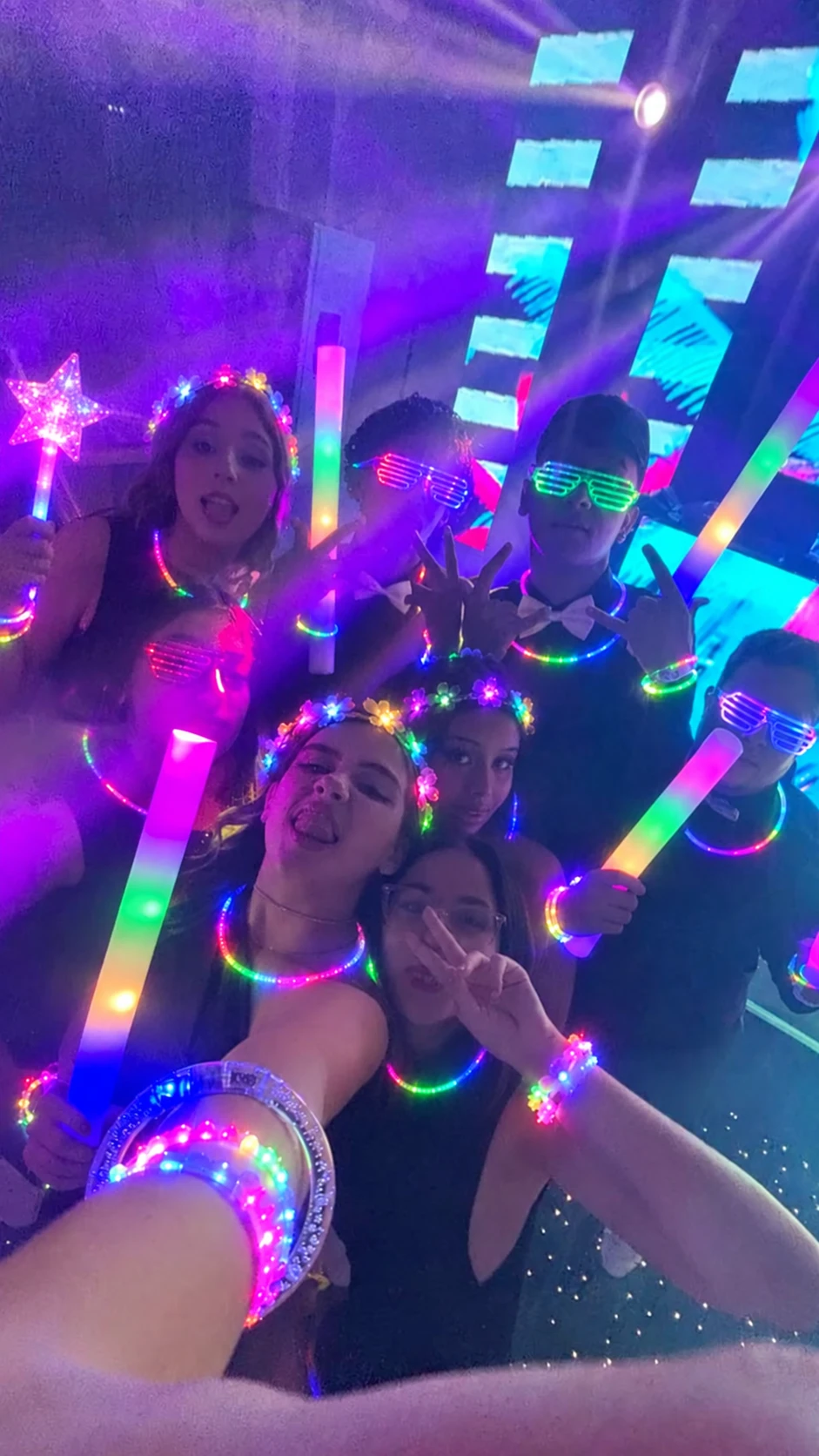 Invitados con pulseras, collares y bastones luminosos de Mi Fiesta Shop en una fiesta de XV años